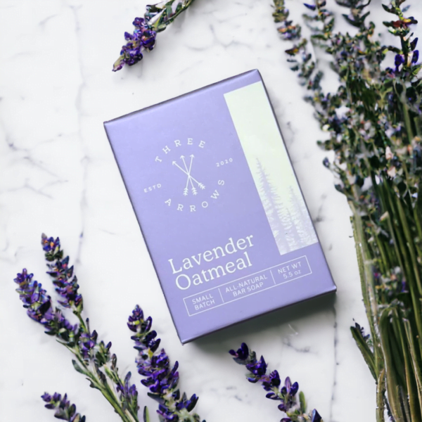 A box of lavender scented bar soap next to sprigs of lavender flowers